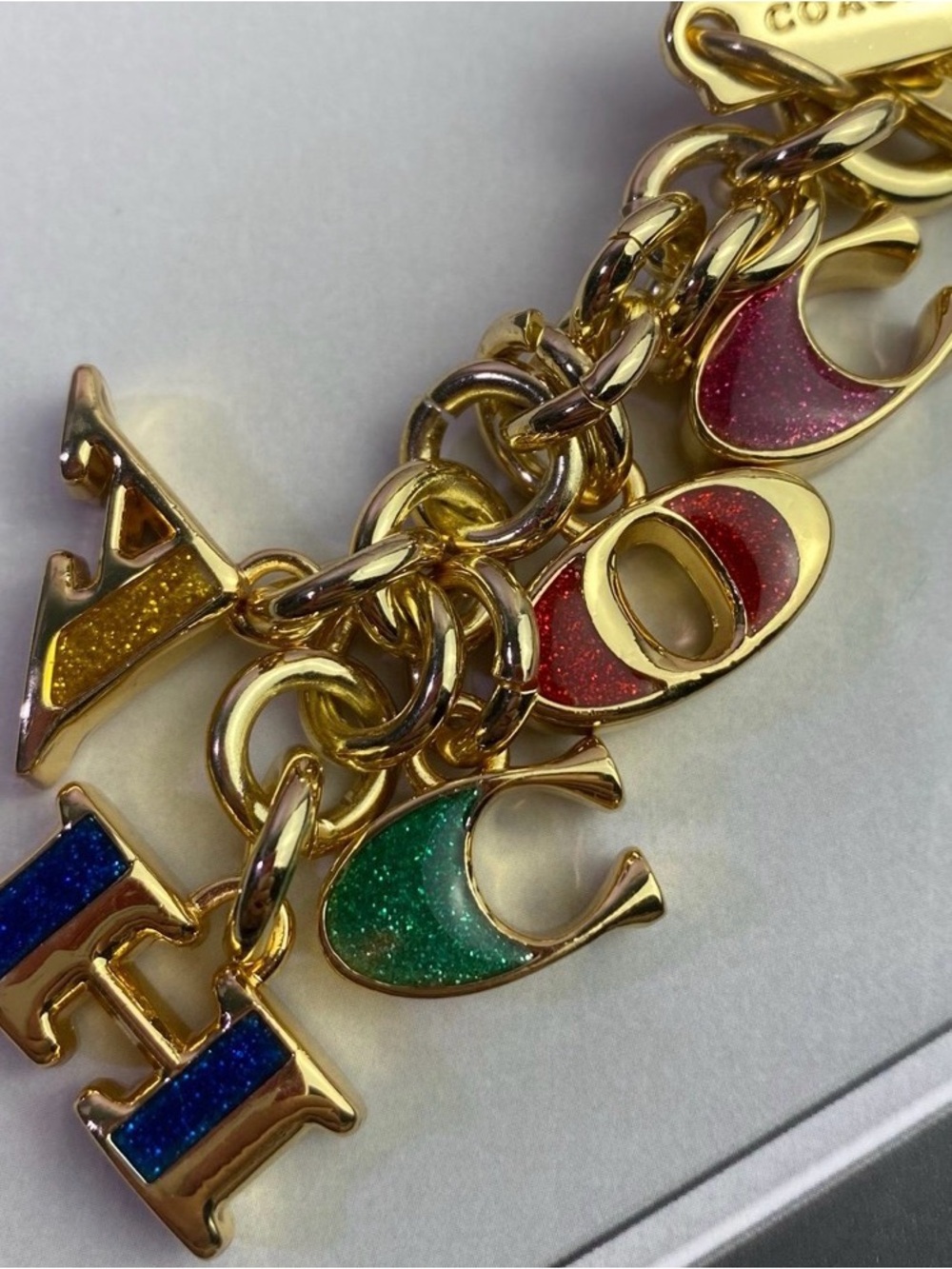 Coach Gold-Tone Charm Bracelet with Blue, Green, Red, Yellow Glitter Letters